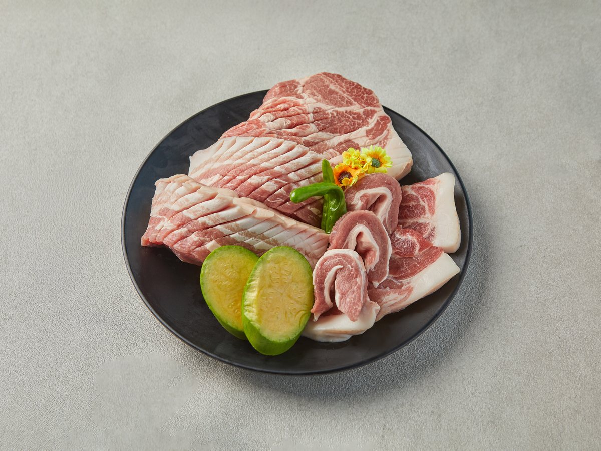바다 세트 — 제주산 한돈과 흑돼지 생고기를 검은 접시에 담은 모습