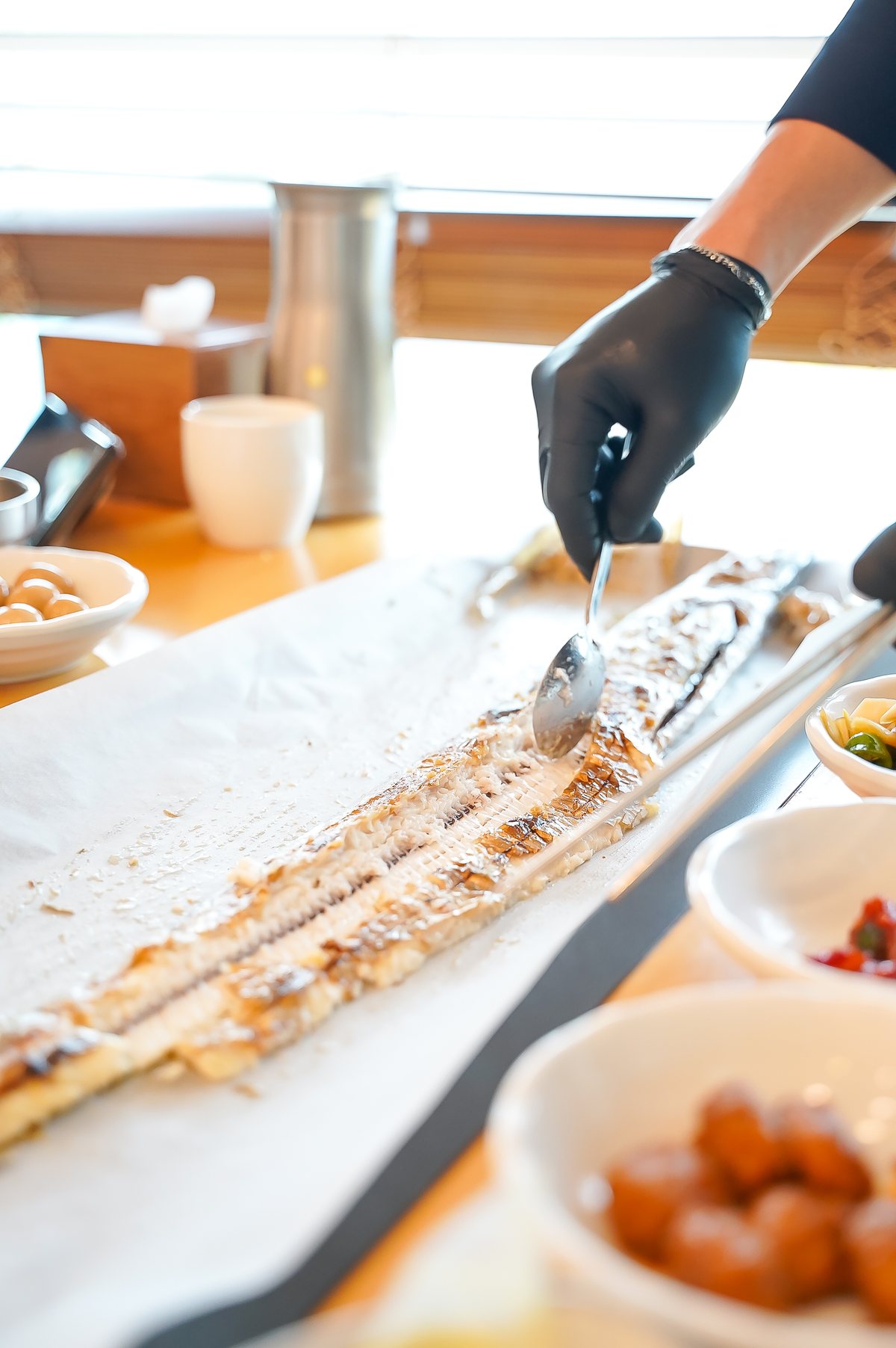 통갈치구이 — 긴 통갈치구이의 뼈를 발라 내는 모습