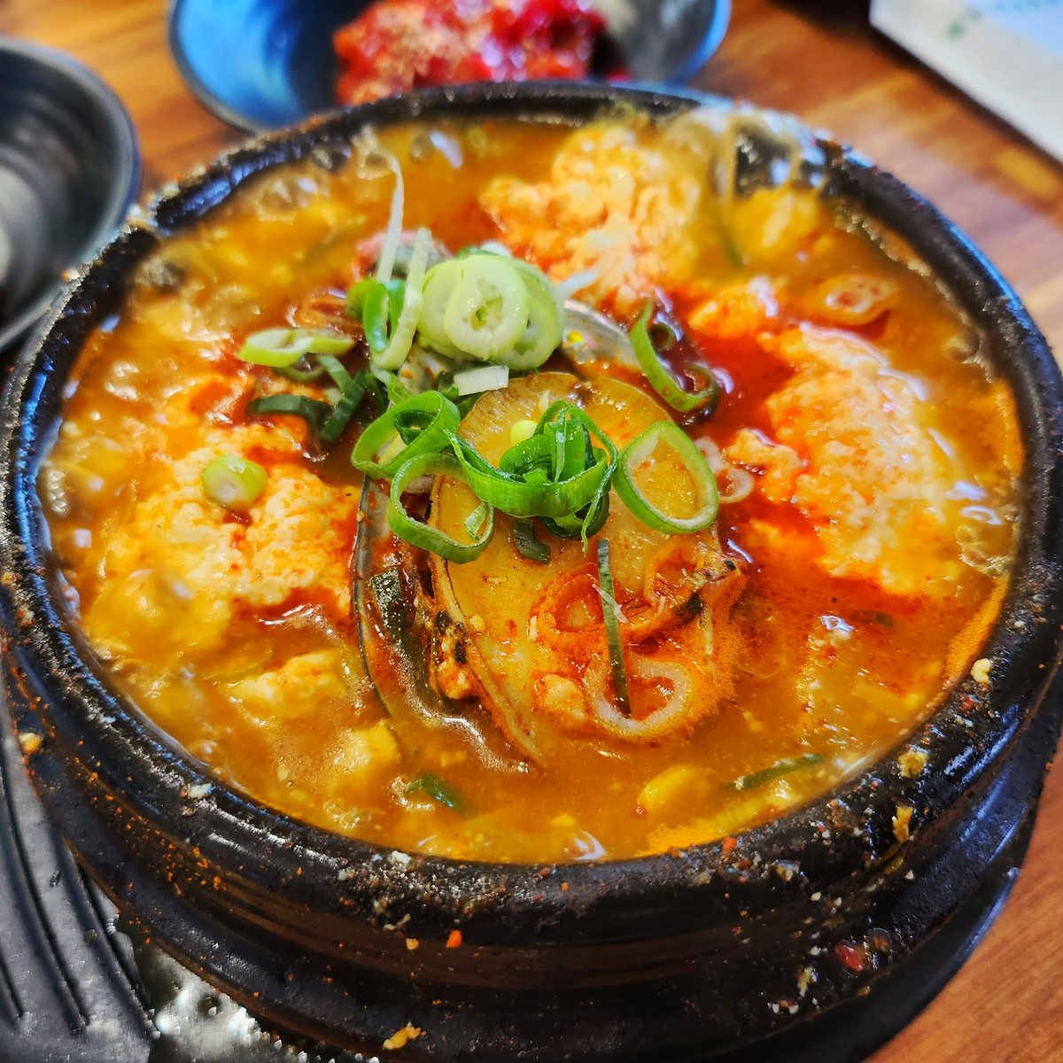 전복 순두부찌개 — 전복과 대파를 올린 붉은 순두부찌개 뚝배기