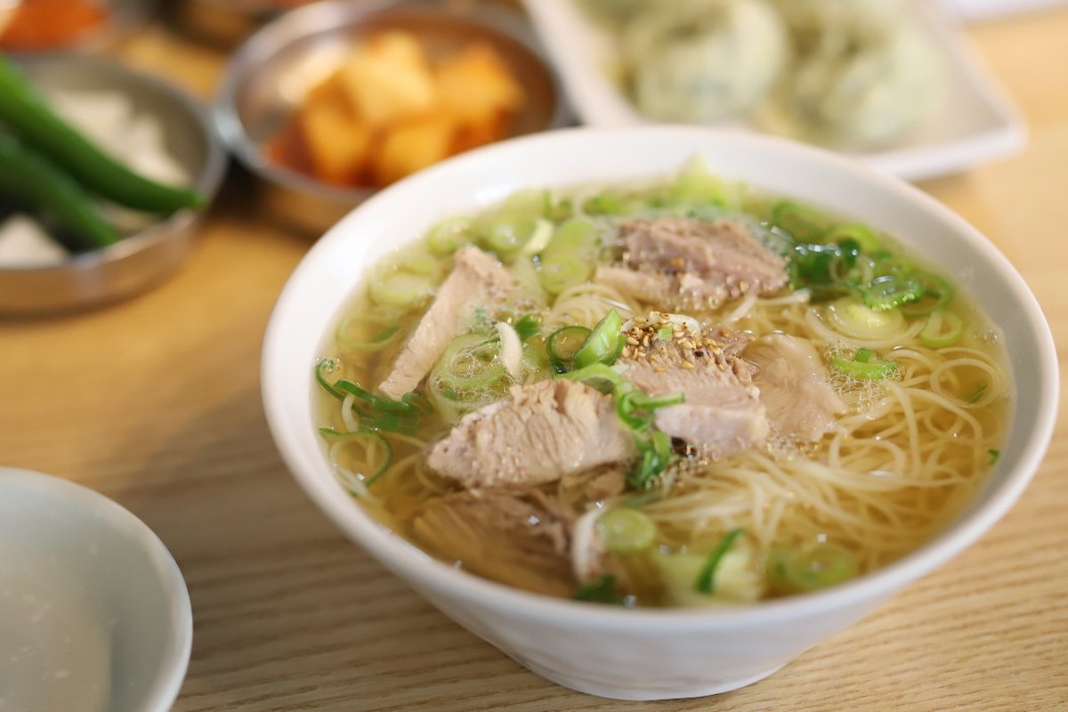맑은 국물에 돼지고기 수육과 쪽파를 올린 국수 한 그릇