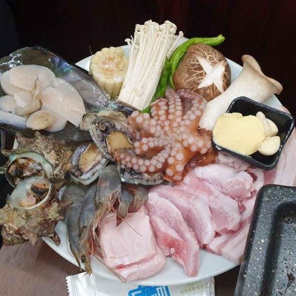 흑돼지 해물삼합 — 굽기 전 문어·전복·소라·새우와 흑돼지를 한 접시에 담은 모습