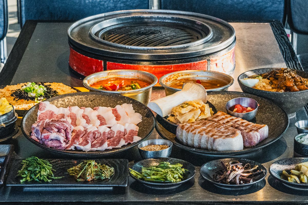 불판 앞에 흑돼지 생고기와 계란찜·찌개·반찬을 차린 상