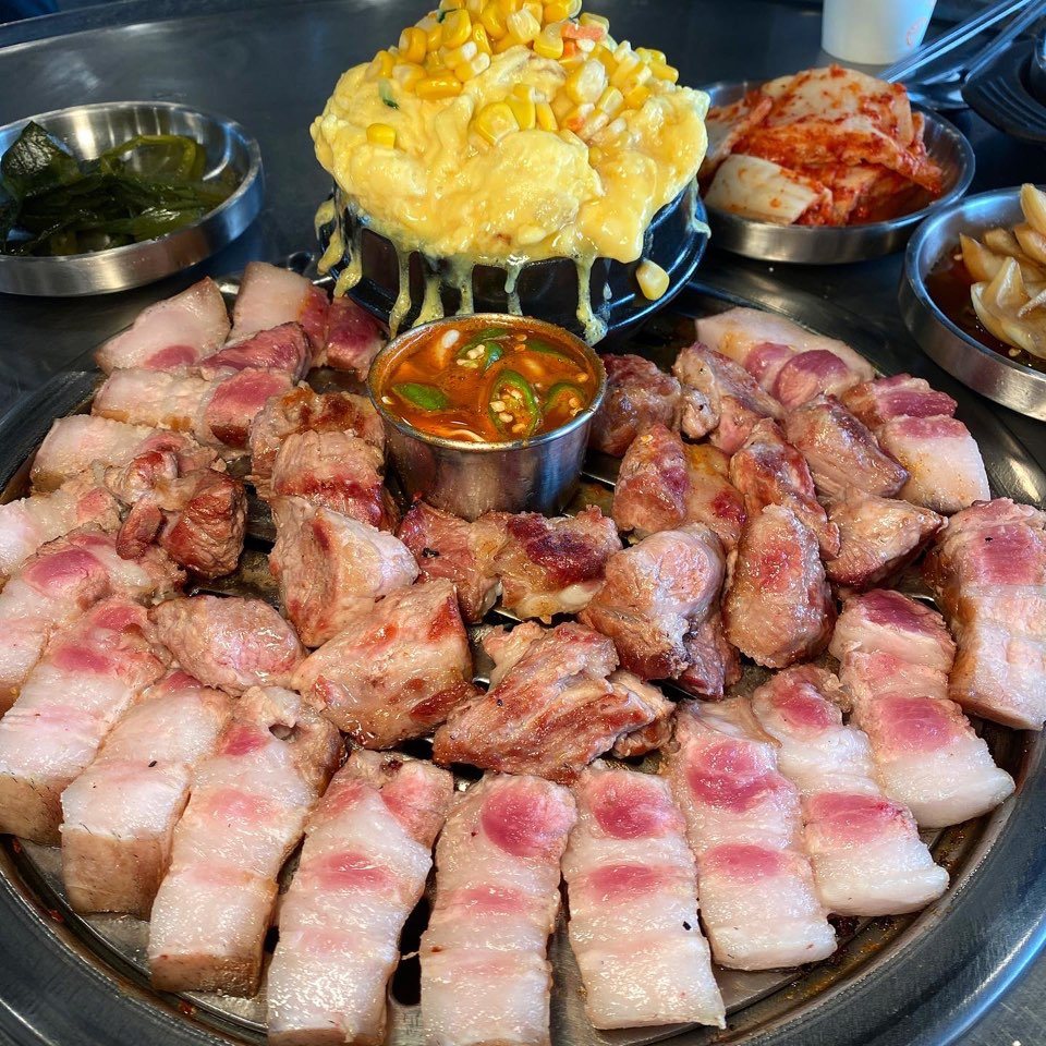 불판 위에서 굽고 있는 흑돼지 근고기와 계란찜·김치